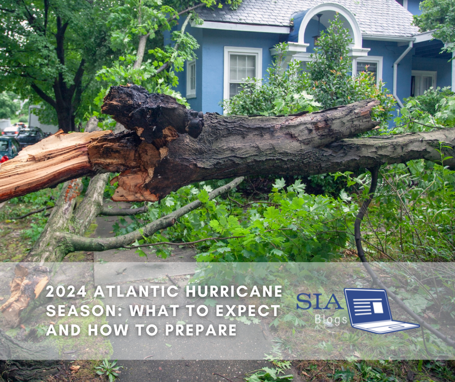 A large fallen tree lies across a sidewalk and in front of a blue house, with broken branches and leaves scattered around. The caption reads, "2024 Atlantic Hurricane Season: What to Expect and How to Prepare," along with the SIA Blogs logo.