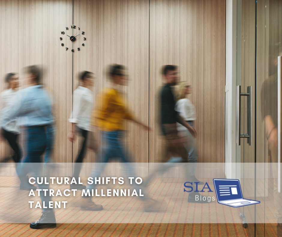 A group of people walks briskly through an office hallway, with motion blur emphasizing their movement. The setting has a modern feel with wooden panel walls and a large clock. The caption reads, "Cultural Shifts to Attract Millennial Talent," along with the SIA Blogs logo.